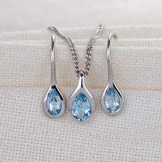 Elegant pear topaz in a rubover setting. Pendant on a chain and matching dangle earrings. Natural African blue topaz 6mm long by 4mm in pendant and 5 x 3mm in each dangle earring giving a total carat weight of 1ct. Topaz are associated with love, self esteem and good fortune. They are the birthstone for December. This elegant necklace and earring set is suitable to wear for daytime or evening wear. It is supplied on a 18 inch sterling silver chain. The pendant, chain and earrings are finished wi Pear-shaped Blue Topaz Jewelry As A Gift, Pear Shaped Blue Topaz Jewelry Gift, Pear Shaped Blue Topaz Jewelry For Gifts, Pear-shaped Blue Topaz Jewelry For Gifts, Teardrop Blue Topaz Jewelry In White Gold, Teardrop Blue Topaz White Gold Jewelry, White Gold Teardrop Blue Topaz Jewelry, Silver Pear-shaped Blue Topaz Jewelry, Topaz Necklace