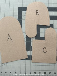 three pieces of cardboard cut out to look like letters and numbers on a cutting mat