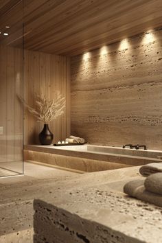 a bathroom with stone walls and lights on the ceiling, along with a large bathtub