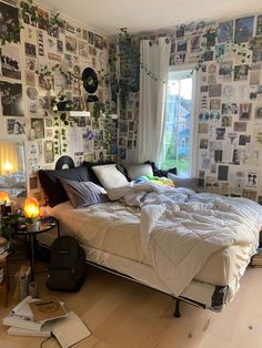 an unmade bed sitting in a bedroom next to a window with lots of pictures on the wall