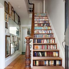 there is a stair case with many books on the shelves and below it are pictures