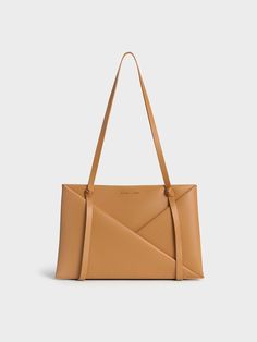 This product is made with at least 20% sustainable materials by weight. CHARLES & KEITH uses recycled, degradable, organic, and water-based materials in our eco-conscious collection. Immediately eye-catching, this Midori tote is a head-turner. The classic rectangular tote silhouette has been elevated with tasteful details -- geometric folds draw the eye to the luxurious camel finish, which is perfectly complemented by sculptural knots on the bag straps. Effortlessly elegant, the minimal design feature clean, flowing lines. Boasting a roomy interior, it will hold all that you need for the day and more. Complete with a detachable and adjustable strap for a hands-free option, this polished carrier strikes a balance between maximum function and visually appealing form. Black Saddle Bag, Chic Crossbody Bag, Stylish Purse, Classic Handbags, Charts For Kids, Luxury Bag, Charles Keith, Zip Wallet, Everyday Bag