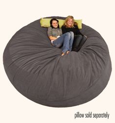 two women sitting on a large bean bag chair with the cover pulled down and pillows folded up