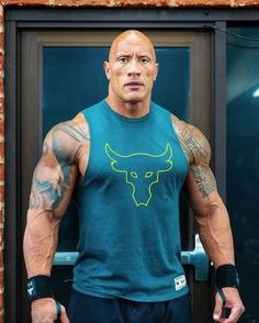 the rock posing for a photo in front of a mirror with tattoos on his arms