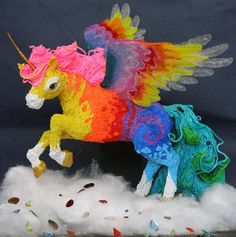 an image of a colorful toy horse on top of some white fluffy material and sprinkles