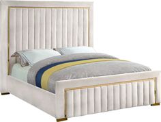 a white bed with gold trimmings on the headboard and foot board is shown