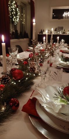 the table is set for christmas dinner with candles