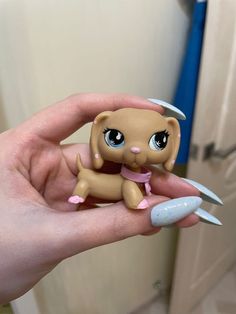 a hand holding a small doll with scissors in it's left hand, next to a door