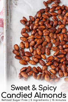 sweet and spicy candied almonds on a baking sheet with text overlay that reads, sweet and spicy candied almonds