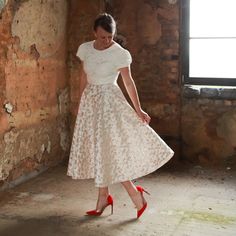 a woman in a white dress and red shoes