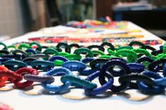 many different colored links on a table with other items in the backgrouf