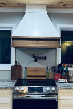 a stove top oven sitting inside of a kitchen next to a counter with cutting boards on it