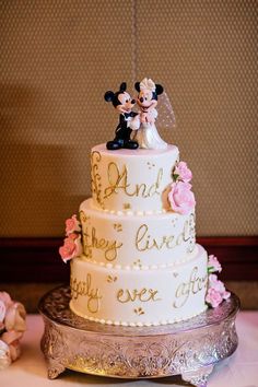 a wedding cake decorated with mickey and minnie mouse figurines