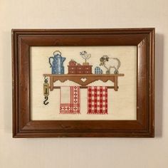 a cross stitch picture hanging on the wall