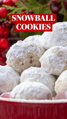 a red bowl filled with powdered sugar covered doughnuts next to christmas decorations