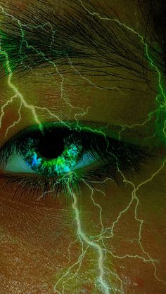 a woman's eye with green and yellow lightning streaks on it, as if she was in the dark