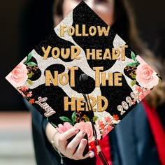 a woman wearing a graduation cap that says follow your heart not the herd