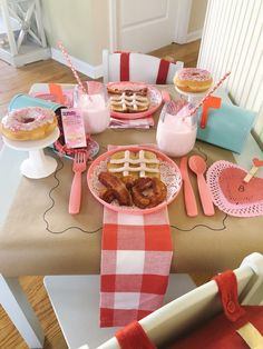 a table topped with plates and cups filled with donuts next to doughnuts