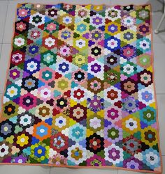 a large multicolored quilt on the floor