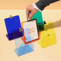 a person holding a clipboard in front of several colored folders on a table