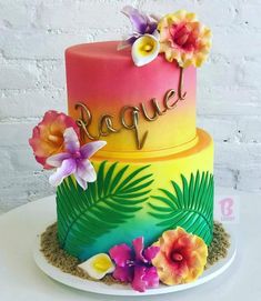 a multi - colored cake with flowers and the word rappel on top is sitting on a plate