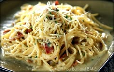 a close up of a plate of food with pasta and sauce on it, in a black bowl