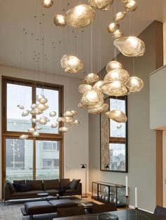 a living room filled with furniture and lots of lights hanging from the ceiling above it