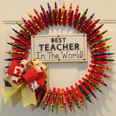 a wreath made out of crayons with the words best teacher in the world