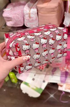 a hello kitty purse is being held up