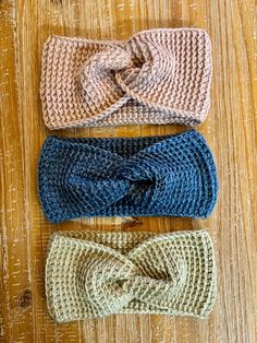 three crocheted headbands on top of a wooden table