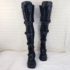 4 1/2" (114mm) Wedge Platform Front Lace-Up Stretch Thigh High Boots W/ Quadruple Skull Buckle Strap & Ornamental Zip Closure Details On The Outside Stretch Polyurethane Faux Leather Full Inner Side Zip Closure Demonia Women's Us Sizes Brand New Tie Up Boots, Rocker Boots, Stretch Thigh High Boots, Goth Shoes, Goth Boots, Demonia Shoes, Dr Shoes, Black Platform Boots, Punk Rocker