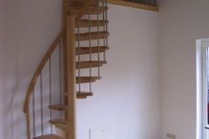 an empty room with a spiral staircase in the corner and a door to another room