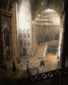 the inside of an old building with stairs and chandeliers in it's center