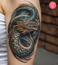 a woman's arm with a green and gold dragon tattoo on the left shoulder