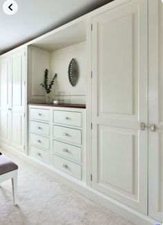 an empty room with white cabinets and drawers