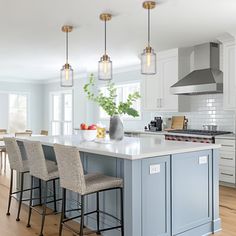 a large kitchen with an island and bar stools