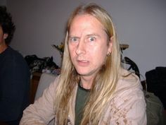 a man with long hair and piercings sitting at a table in front of a woman