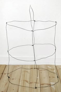 a wire sculpture sitting on top of a wooden floor