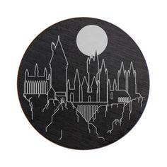 a black and white photo of a city skyline with the moon in the sky above it