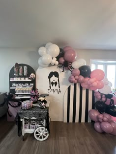 the room is decorated with balloons and black and white decor, along with an assortment of other items