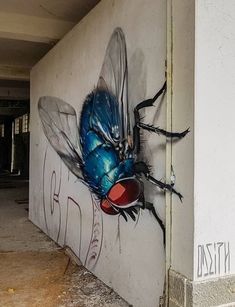 a blue insect painted on the side of a building