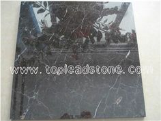 black marble tile with white veining on the top and bottom, which has been used as a wall decoration