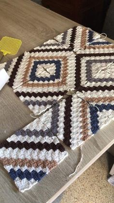 there are two pieces of crocheted fabric on the table next to each other