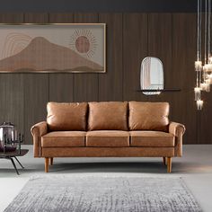 a brown leather couch sitting on top of a rug