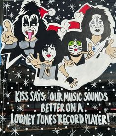 a sign on the side of a building that reads kiss says, our music sounds better on a london times record player