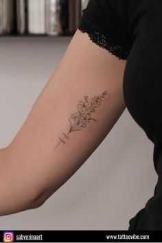 a woman's arm with a tattoo on it that has flowers growing out of it