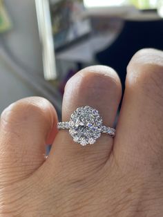 a close up of a person's hand holding a diamond ring