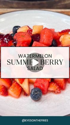 a white plate topped with sliced fruit on top of a wooden table next to a bottle of watermelon summer berry salad