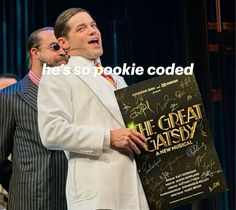 two men standing next to each other in front of a sign that says he's so pokie cooedd