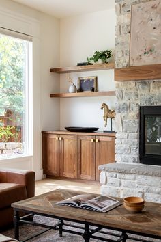 a living room filled with furniture and a fire place in front of a brick wall